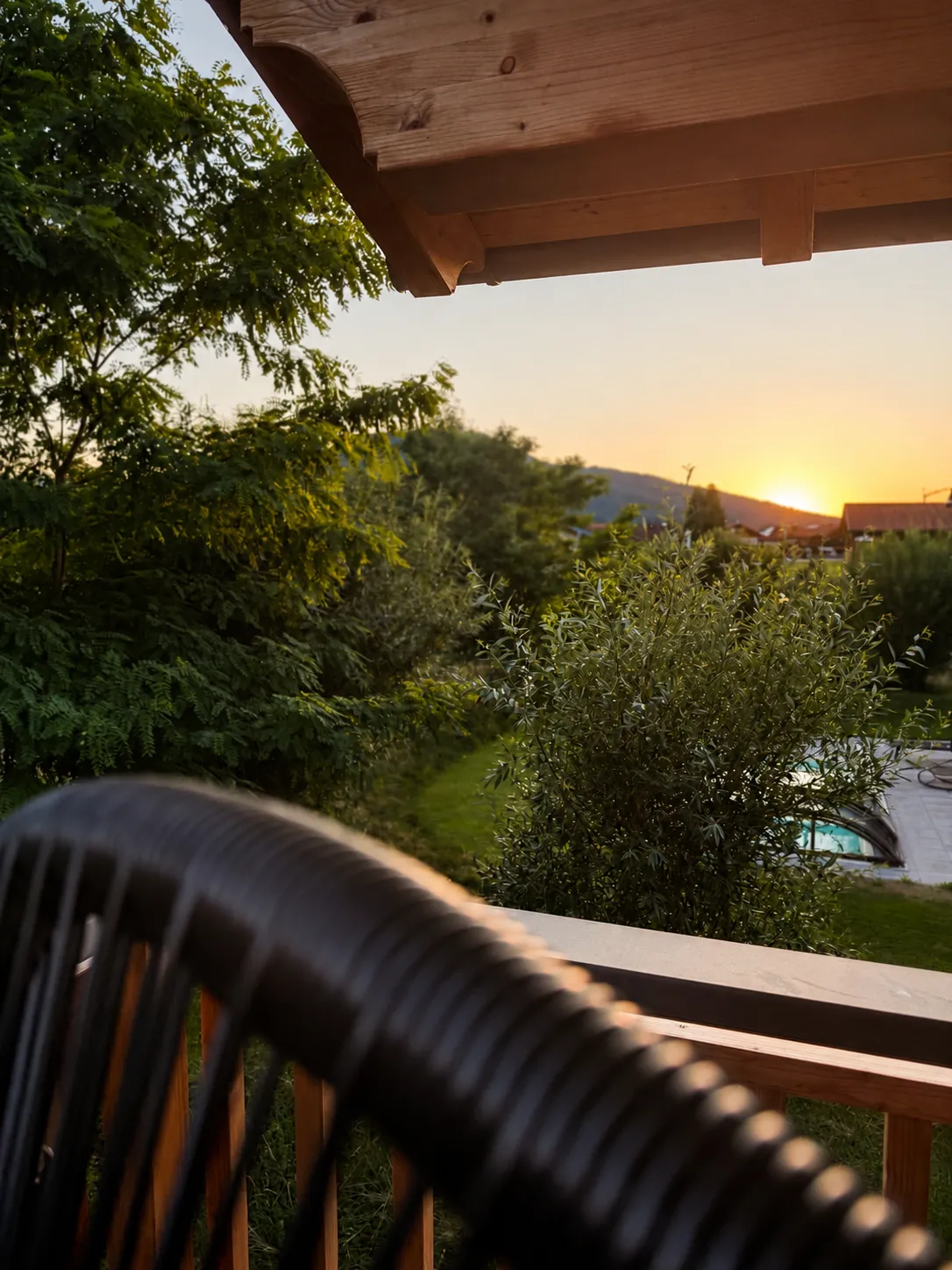 Sonnenuntergang über Garten und Pool vom Balkon