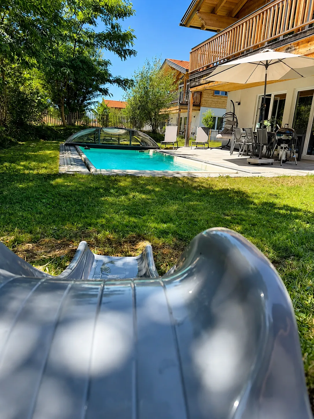 Eingezäunter Garten mit Pool und Kinderrutsche
